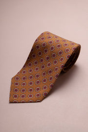 Dark champagne coloured tie with a subtle red geometric floral pattern
