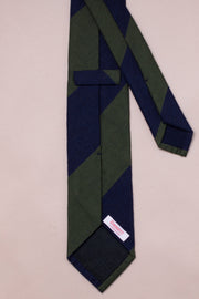 Two-tone green and navy silk and wool tie on a beige background