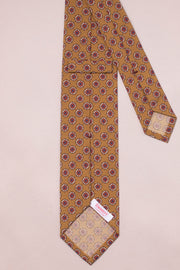 Dark champagne coloured tie with a subtle red geometric floral pattern